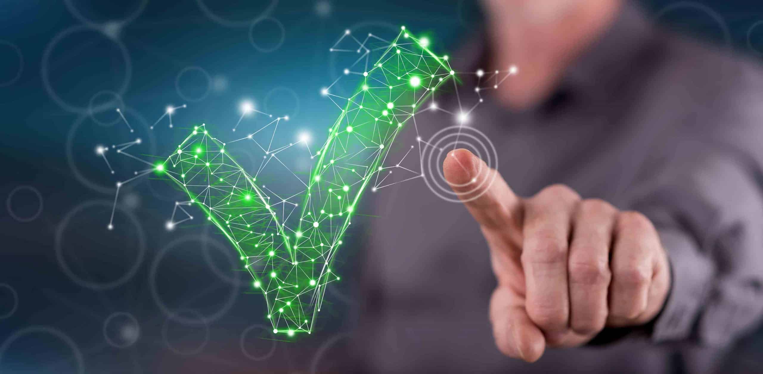 Hand zeigt auf holografisches grünes Häkchen aus vernetzten Punkten und Linien.